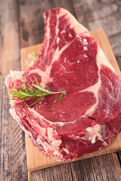 Raw beef with rosemary on wood - Фото, зображення