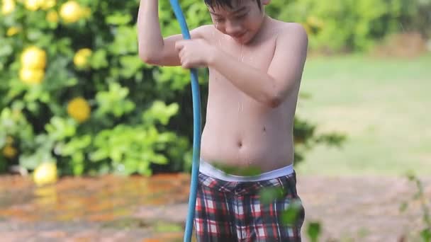 heureux asiatique enfant jouer éclaboussures avec caoutchouc tube eau sur Chaud été
 - Séquence, vidéo