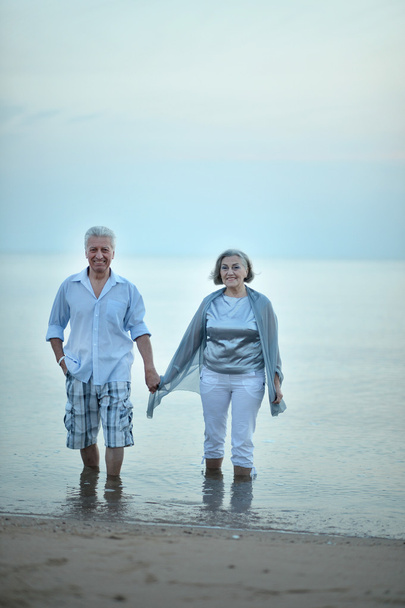 Vanhukset pari kävelee pitkin rantaa
 - Valokuva, kuva