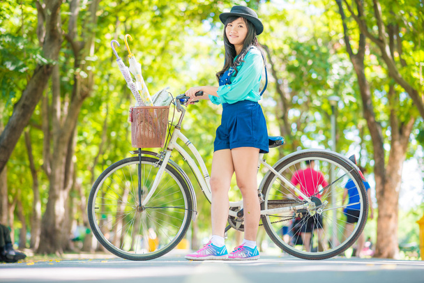 Jeune belle femme asiatique avec vélo dans le parc d'été
 - Photo, image