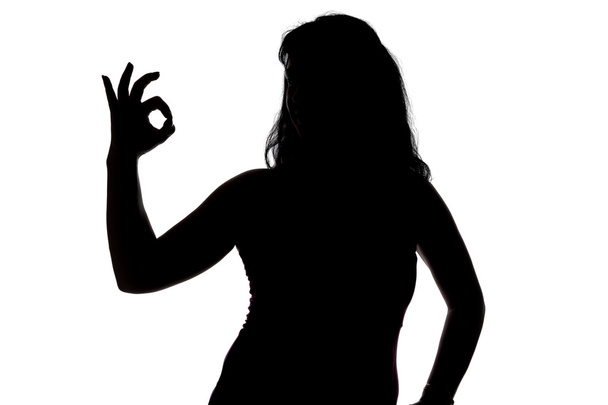 Foto der Silhouette einer Frau, die Okey zeigt - Foto, Bild