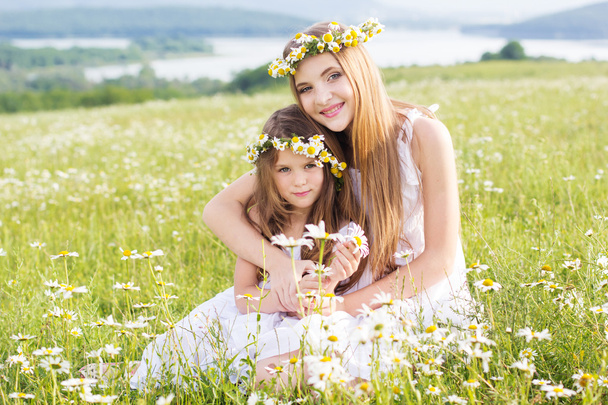 Twee kind meisjes op veld met bergen weergeven - Foto, afbeelding