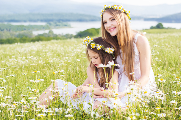 Two child girls at field with mountains view - Foto, imagen