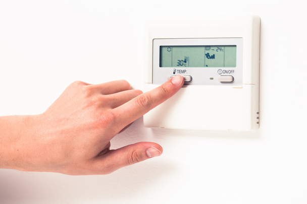 termostato digital del clima que controla a mano
 - Foto, imagen