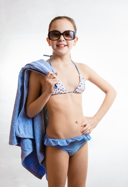menina sorridente feliz em óculos de sol segurando toalha de praia
 - Foto, Imagem