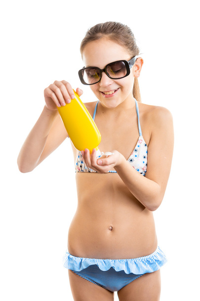 Isolated portrait of smiling girl pouring suntan lotion on hand - Photo, Image