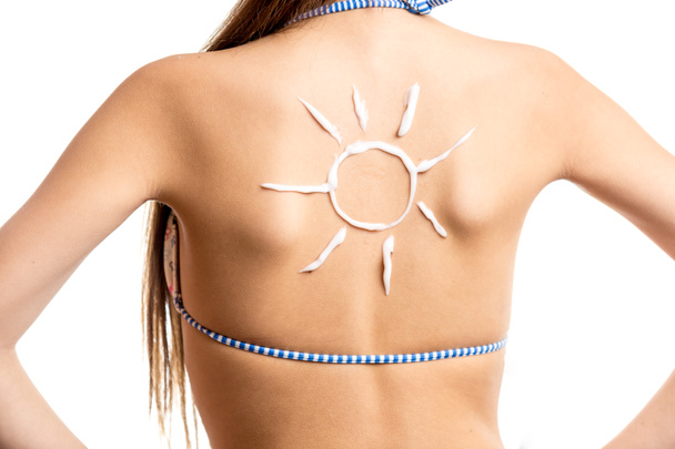 isolated shot of sun drawn by sun lotion on girls back - Photo, Image