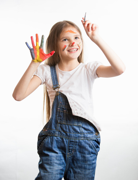 schattige lachende meisje met geschilderde gezicht en handen tekenen in de lucht - Foto, afbeelding