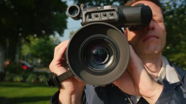 Un primer plano de un camarógrafo enfocando una cámara montada en el hombro
. - Metraje, vídeo