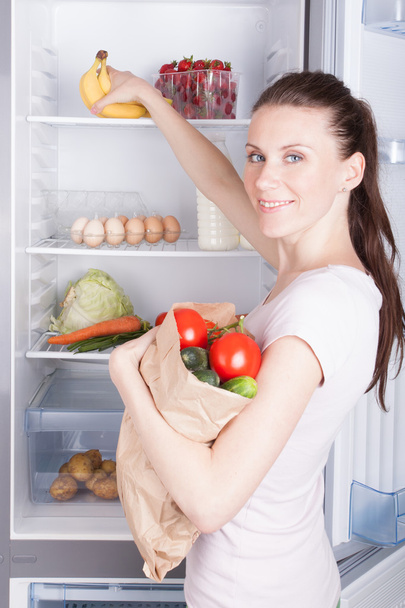 Woman near the refrigerator with healthy food. - Φωτογραφία, εικόνα