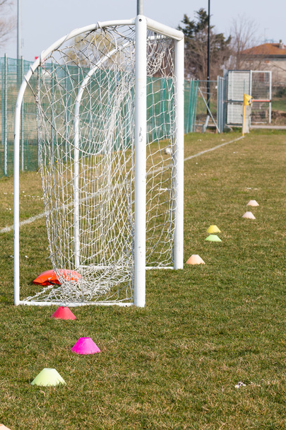 Маленькие футбольные цели и красочные делимитаторы в зеленом цвете на открытом воздухе
 - Фото, изображение