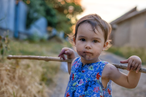 Küçük ve onu sopa ile kirli kız - Fotoğraf, Görsel