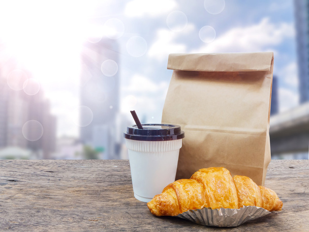 kávé és croissant reggelire papír zsák - Fotó, kép