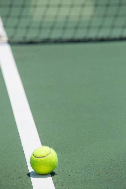 μπάλα του τένις στο γήπεδο με το δίχτυ στο παρασκήνιο - Φωτογραφία, εικόνα