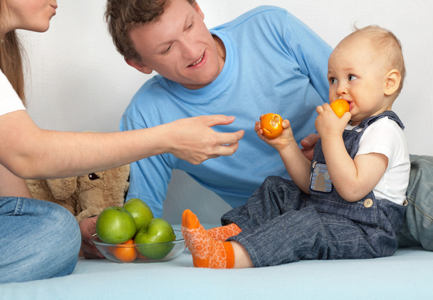 Kid in the family eats tangerines. - Фото, зображення