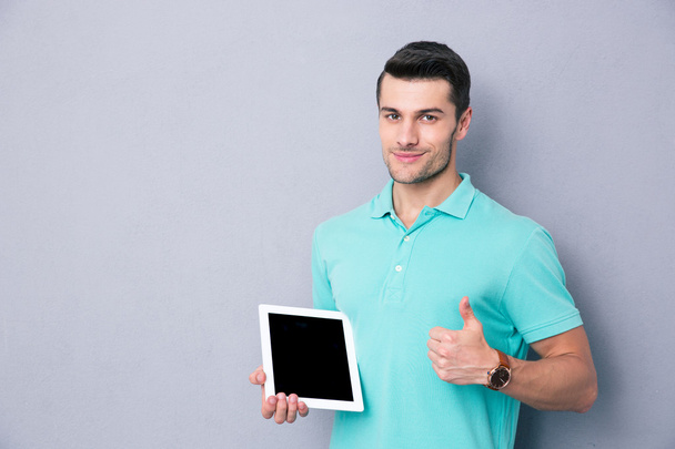 Man holding tablet computer and showing thumb up - Valokuva, kuva