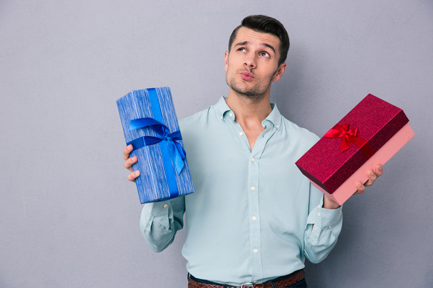 Pensive young man holding two gift box - Photo, Image