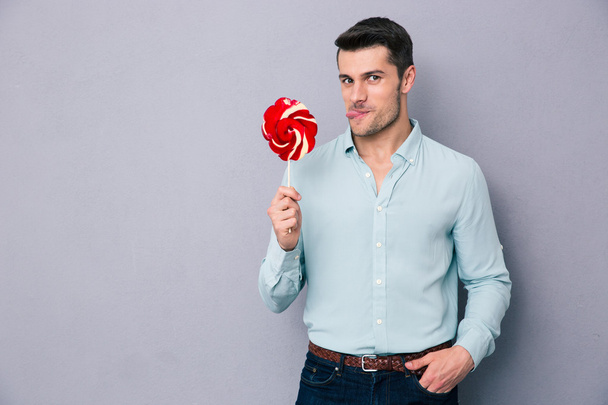 Funny young man holding lollipop  - Foto, afbeelding