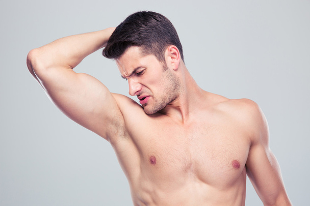 Young man sniffing his armpit - Photo, Image