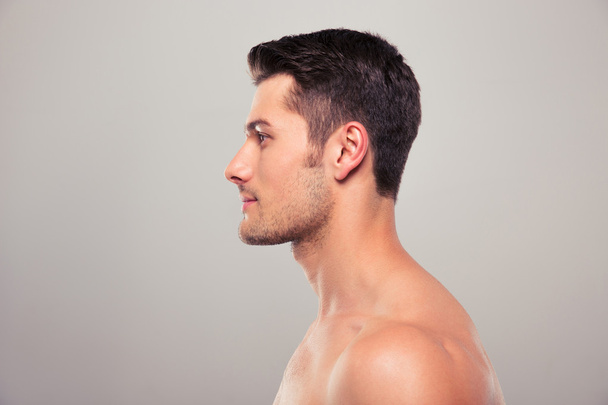 Side view portrait of a young man with nude torso - Фото, изображение