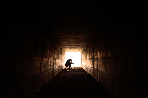 smutny człowiek siedzi w tunelu - Zdjęcie, obraz