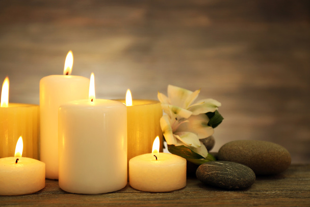 Beautiful composition with candles and spa stones on wooden background - Фото, зображення