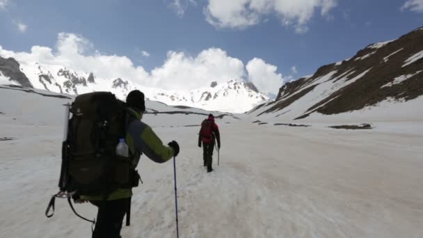 Climbers walking on snowy mountain - Кадры, видео