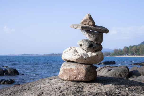 Стопка гальки на большом камне на пляже
. - Фото, изображение