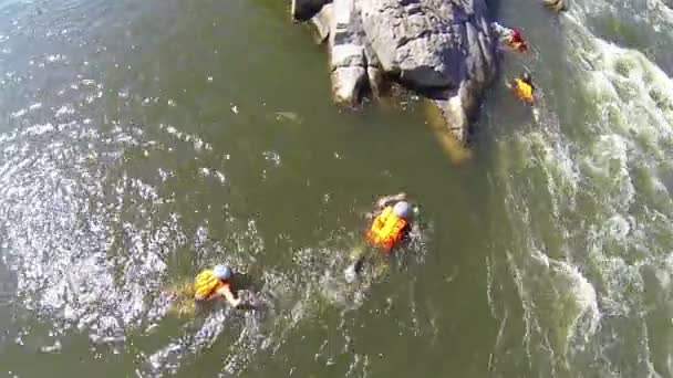 Mensen in reddingsvesten in berg rivier. Luchtfoto terug naar boven - Video