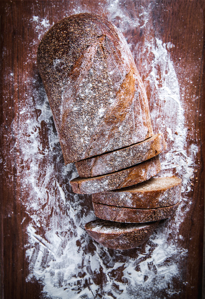 food. sliced rye bread on a wooden background. Bread flour - Foto, Bild
