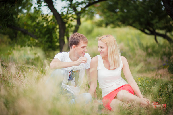 couple sitting on the grass in the park - Foto, imagen