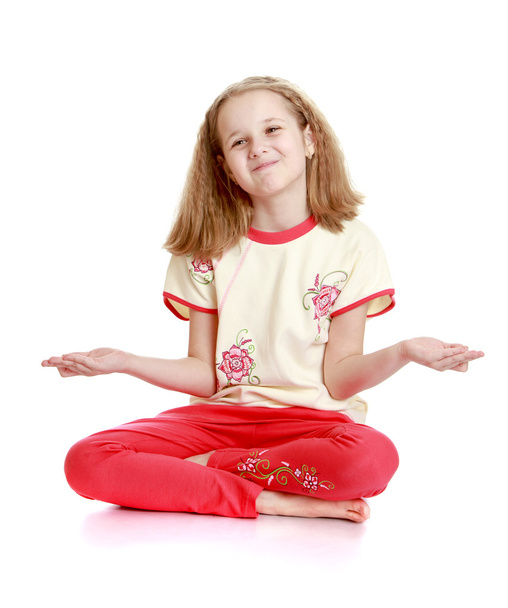 Beautiful blond little girl sitting on the floor meditating in t - Photo, Image