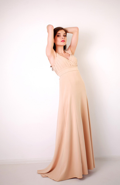 Fashion young brunette woman in pastel long dress in studio - Photo, image