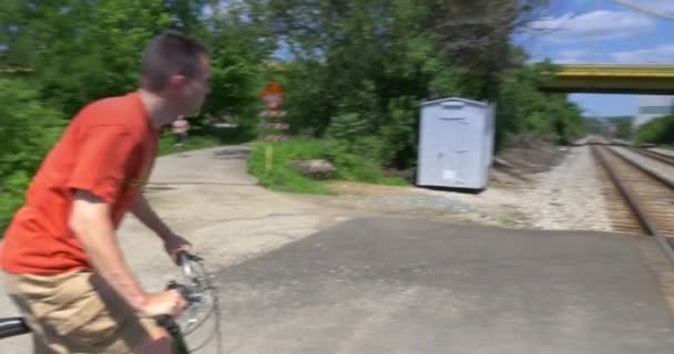 4k Mann auf Fahrrad überquert Bahnübergang - Filmmaterial, Video