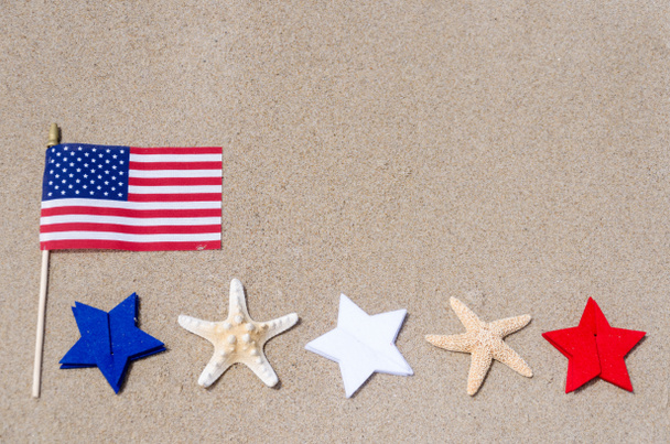 Bandiera amricana con stelle marine sulla spiaggia di sabbia
 - Foto, immagini