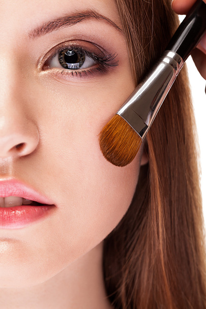Κορίτσι με καθαρό δέρμα εφαρμογή make up με βούρτσα - Φωτογραφία, εικόνα