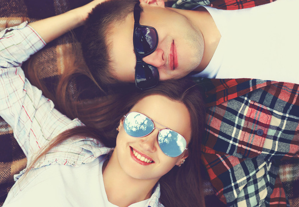 Closeup portrait of happy young couple in sunglasses lying on th - Photo, Image