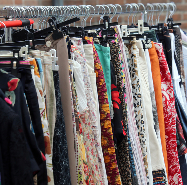 винтажная одежда, висящая на открытом рынке подержанных вещей
 - Фото, изображение