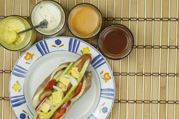 Domestic hot-dog with vegetables, fast food preparation at home. - Foto, Bild