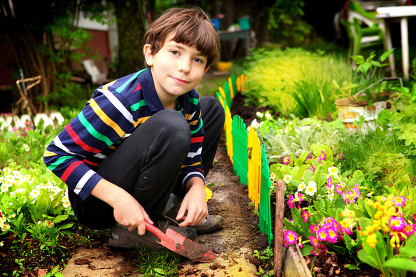 a virágzó kertet preteen jóvágású fiú munkát - Fotó, kép