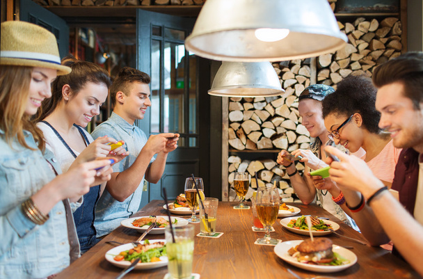 happy friends with smartphones picturing food - Foto, Imagem