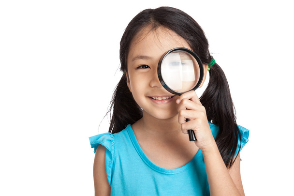 Little asian girl with magnifying glass - Фото, изображение