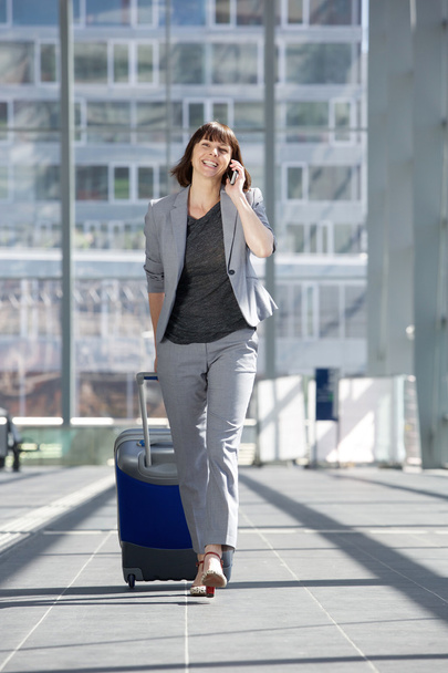 boldog üzleti nő beszél a mozgatható telefon-nél repülőtér   - Fotó, kép