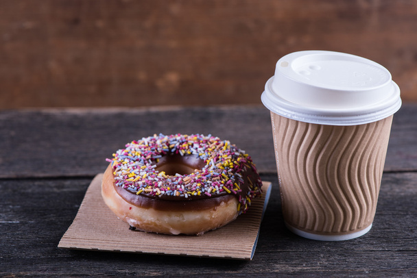 frischer handwerklicher Donut und Kaffee zum Mitnehmen, Holzhintergrund - Foto, Bild