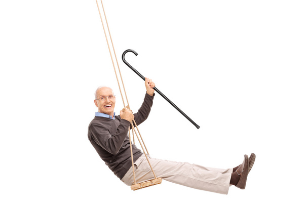 Joyful senior swinging on a swing  - Valokuva, kuva