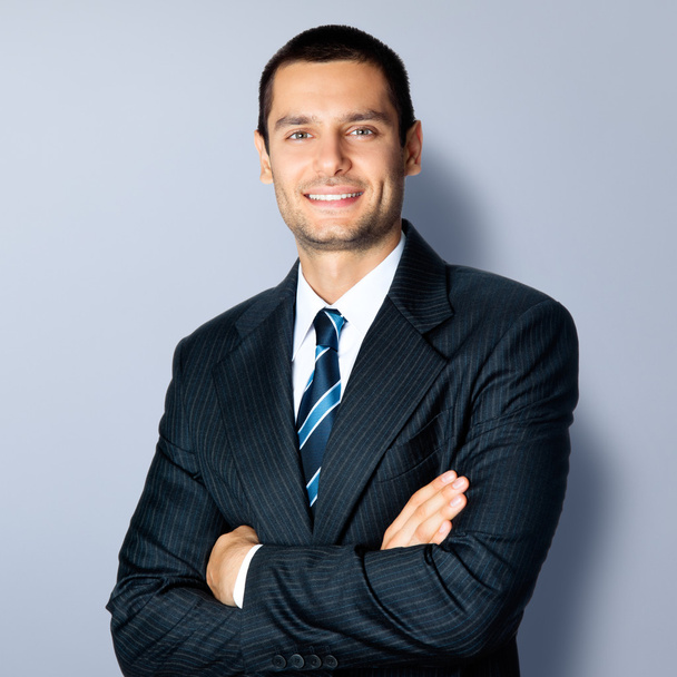 Happy smiling businessman with crossed arms, over grey - Φωτογραφία, εικόνα
