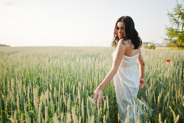Pregnant gorgeous brunette woman on the field with wheat and pop - Foto, afbeelding