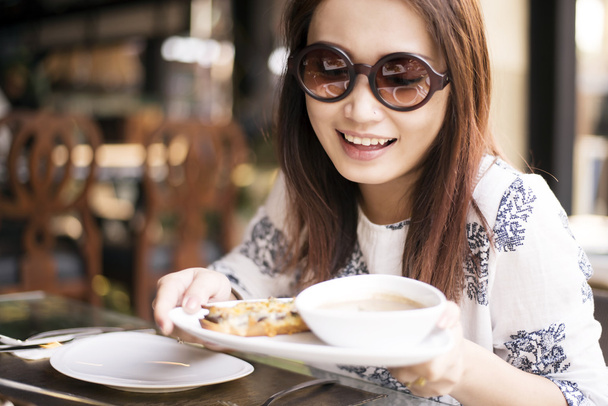 Mujeres jóvenes felices comiendo sopa de crema de champiñones
 - Foto, imagen