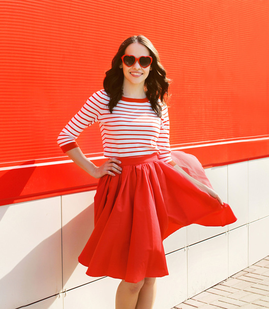 Pretty woman in red sunglasses and dress against the colorful wa - Photo, image