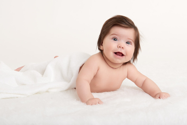 bébé heureux sous la serviette sur blanc
 - Photo, image
